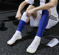a man sitting on the floor with a pair of socks on his feet